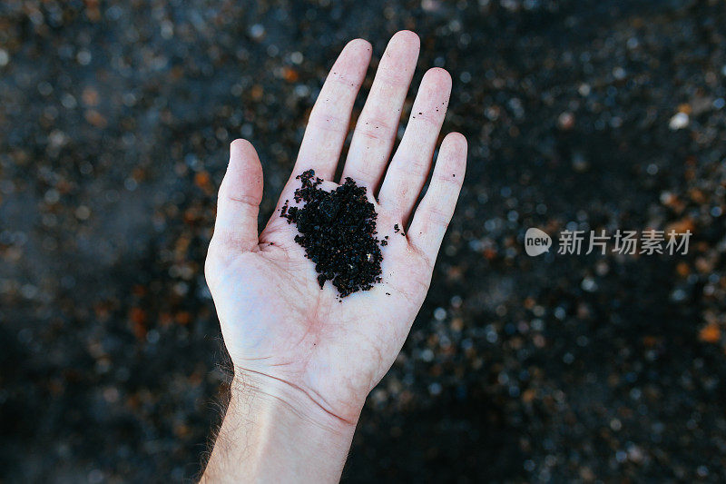 印尼巴厘岛，一个女人的手牵着火山灰