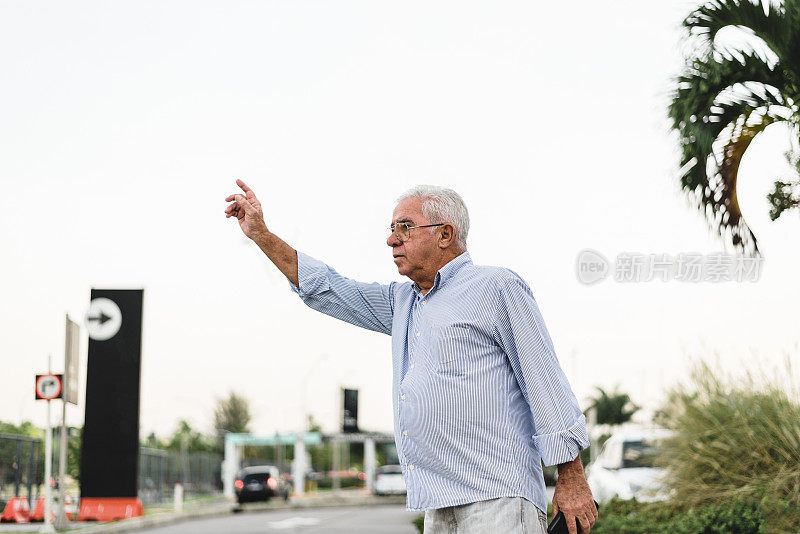 老人在城市里打出租车信号
