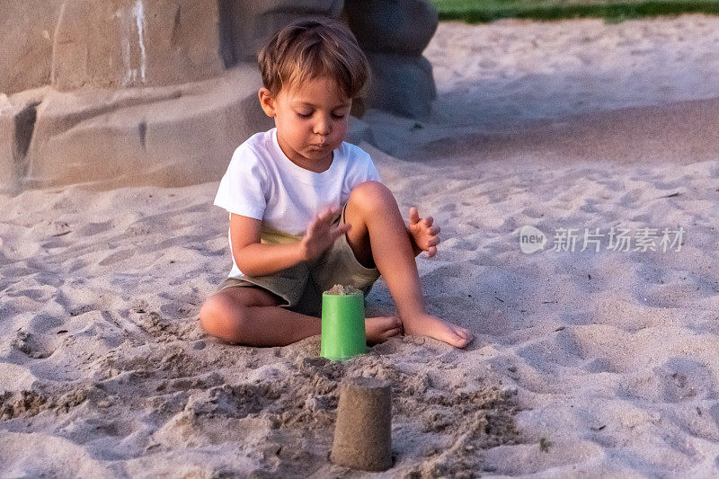 一个小男孩在玩沙子
