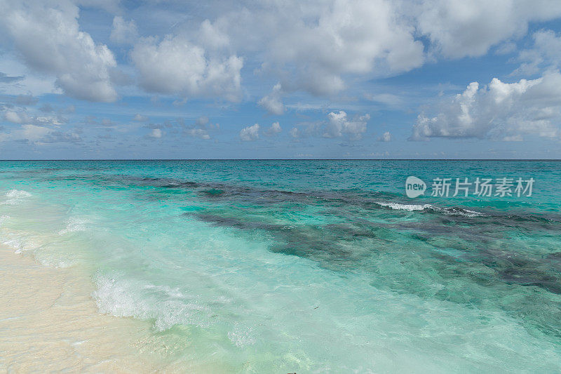 马尔代夫的热带岛屿，绿松石海，椰子树和蓝天。印度洋上的日落