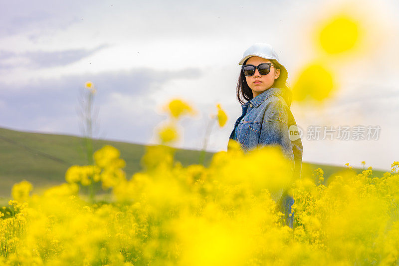 一个十几岁的女孩在油菜花中