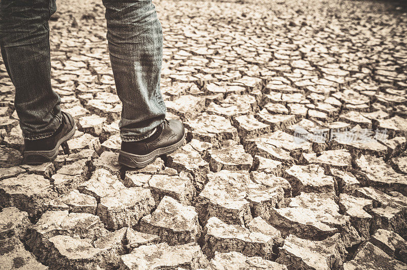 一个人站在干旱的土地上
