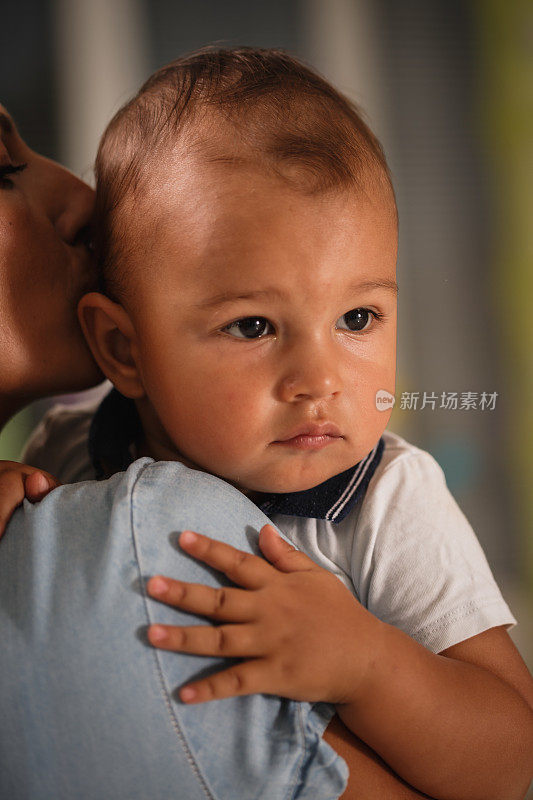 妈妈亲他的时候，小男孩看向别处