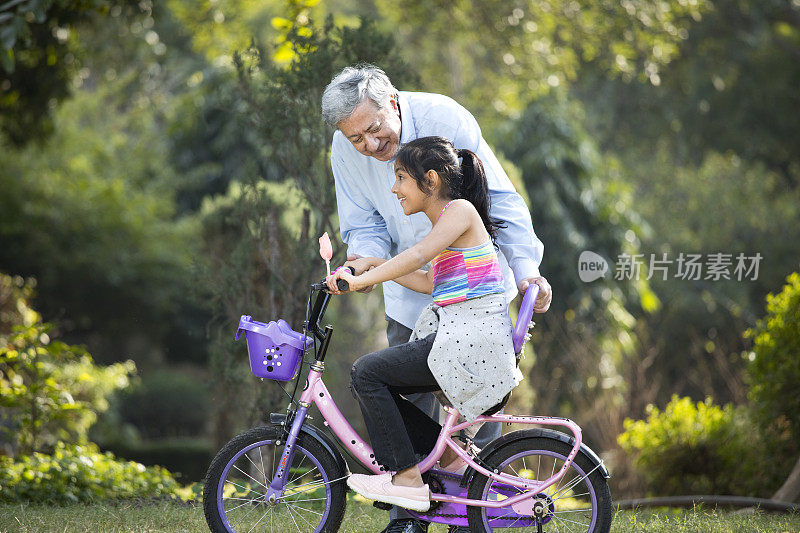 女孩和爷爷一起学骑自行车