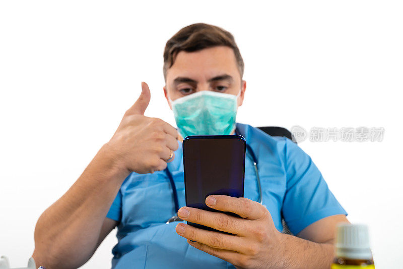 男医生对着智能手机的摄像头竖起大拇指