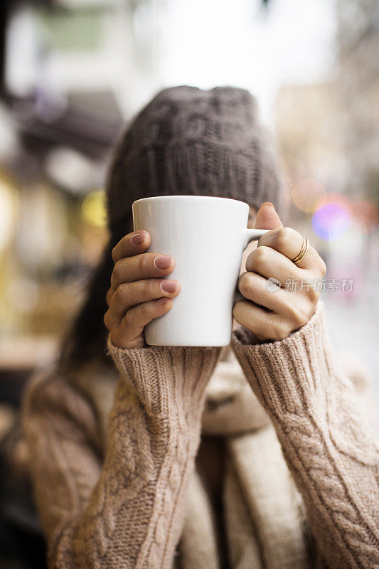 咖啡杯，女士的手拿着咖啡杯，女士拿着一个白色的杯子