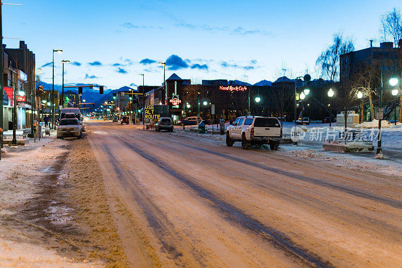 冬季黎明时分，阿拉斯加安克雷奇市中心的西第四大道。空城街;车停了，太阳升起来了。硬石咖啡厅和其他店铺开业。