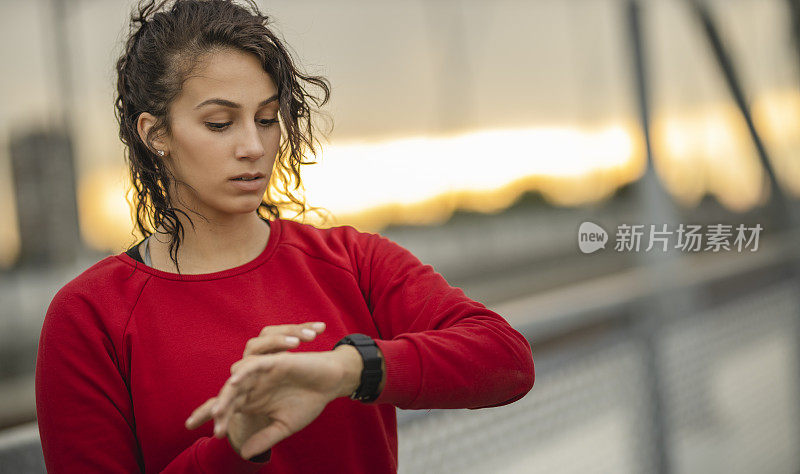 年轻的运动女性在智能手表上检查心率