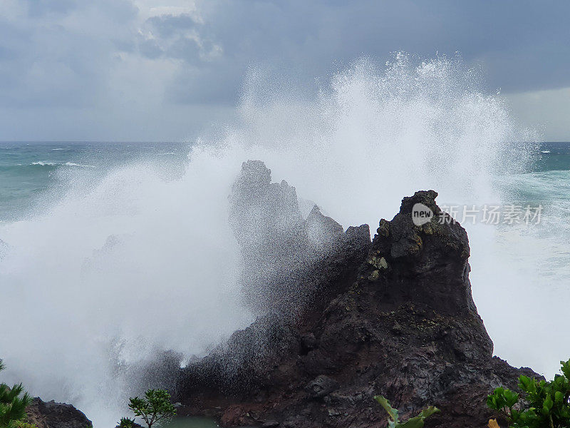 海浪拍打着岩石溅起水花