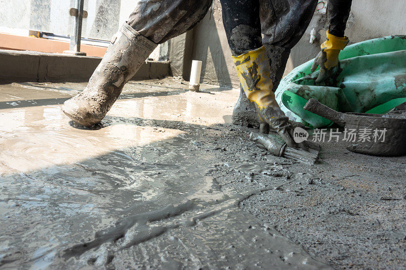 工人将水泥和防水材料混合在地板上制作纺织品