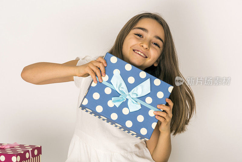 快乐的小女孩手里拿着礼物盒在白色的背景