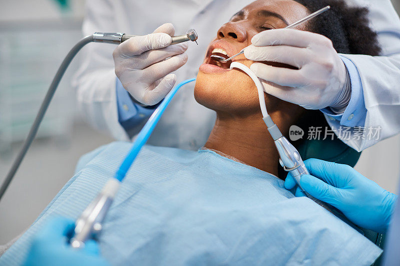 一名黑人妇女在牙科诊所接受牙齿治疗期间进行牙钻手术。