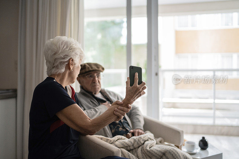 老夫妇在家里用智能手机打视频电话