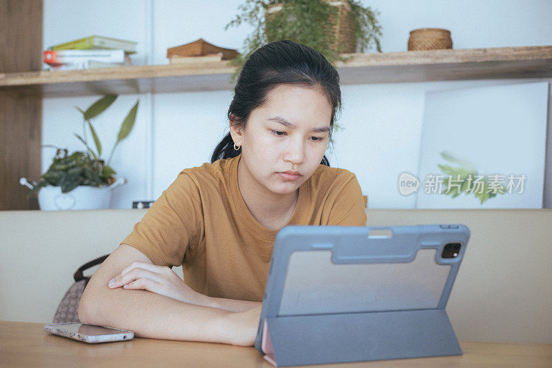 亚洲年轻女学生打算通过数字平板电脑在线学习