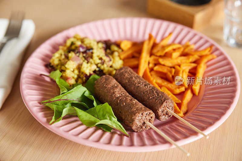 素食餐，以植物为基础的羊肉串，甘薯薯条，蒸粗麦粉和沙拉