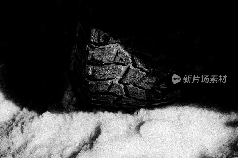 阳光照射在雪地上的四个汽车轮胎上