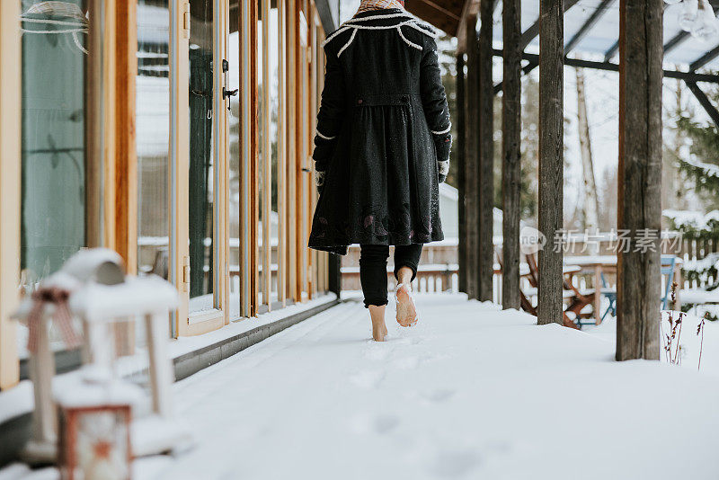 女人赤脚在寒冷的雪地里行走