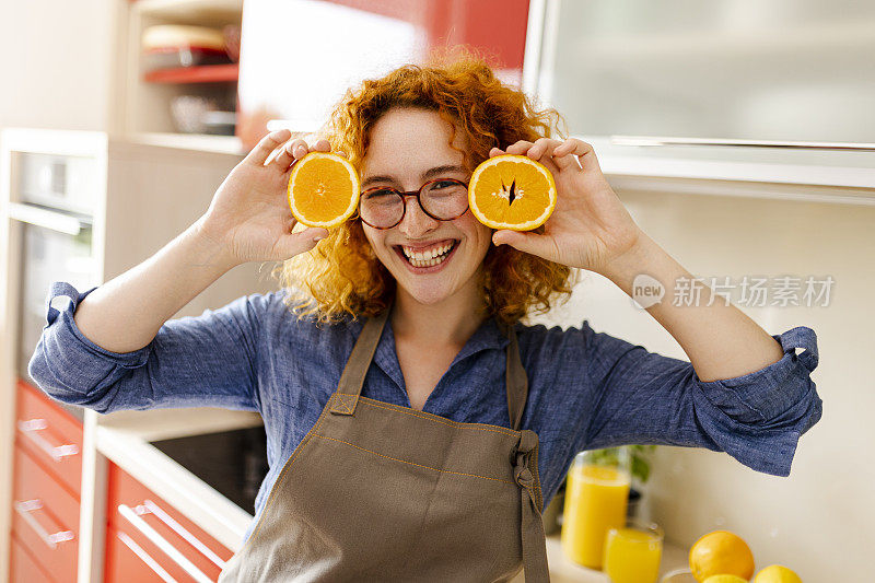 年轻女子在做橙汁的画像