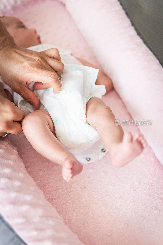 男人给婴儿穿尿布的手的选择性聚焦