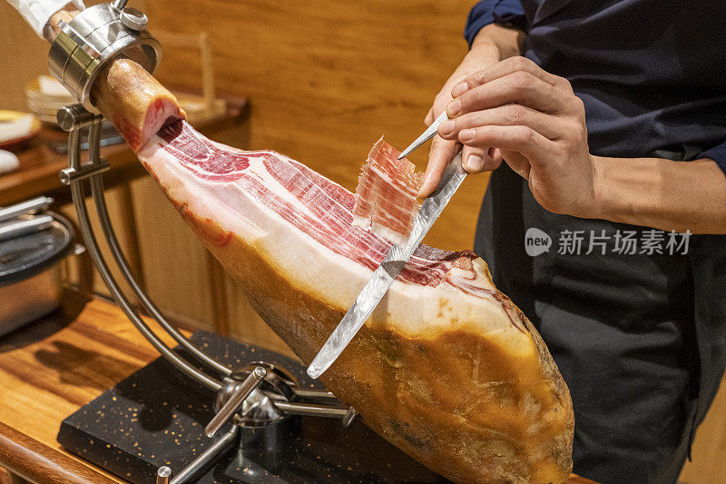 在一家日本餐馆里，厨师正在切西班牙火腿刺身