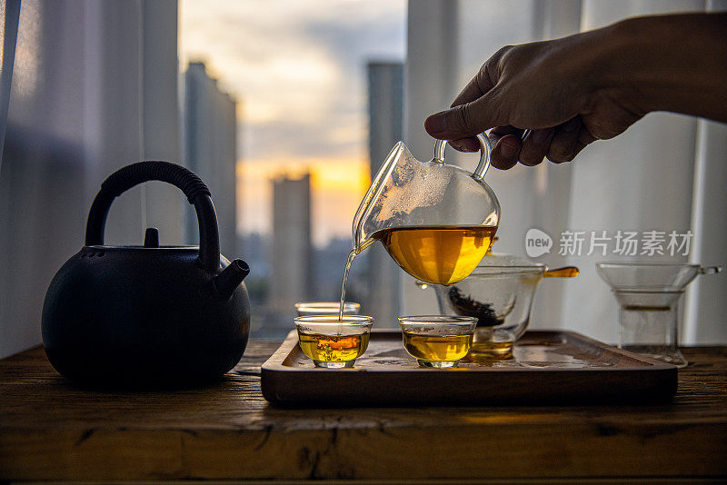 用手将中国茶倒入玻璃杯中