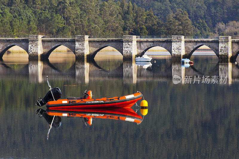 Pontenafonso中世纪石桥，系泊船只。一个Coruña省，加利西亚，西班牙。红色的充气艇。民用保护标志，西班牙语。