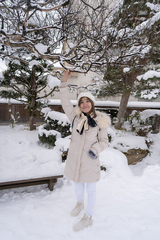 美丽的女子游客享受他们的日本之旅在雪的冬天。