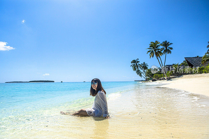 美女在碧海蓝天美丽海滩棕榈树的马尔代夫