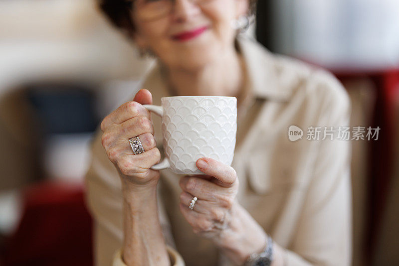 一个微笑的女人端着咖啡杯