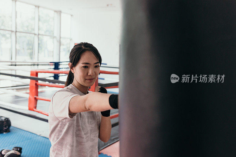 在训练馆里练习自由搏击的亚洲女子