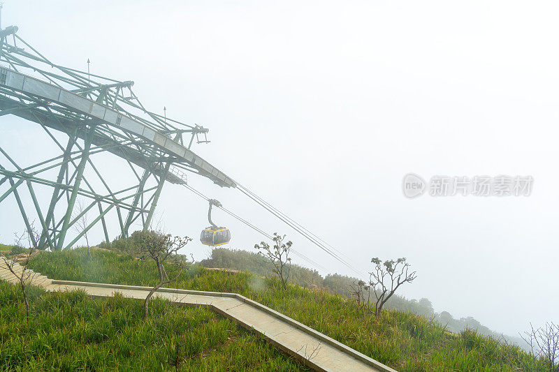 在越南北部萨帕的凡西潘山上，游客乘坐运输机篮旅行。凡西潘山朦胧的早晨。