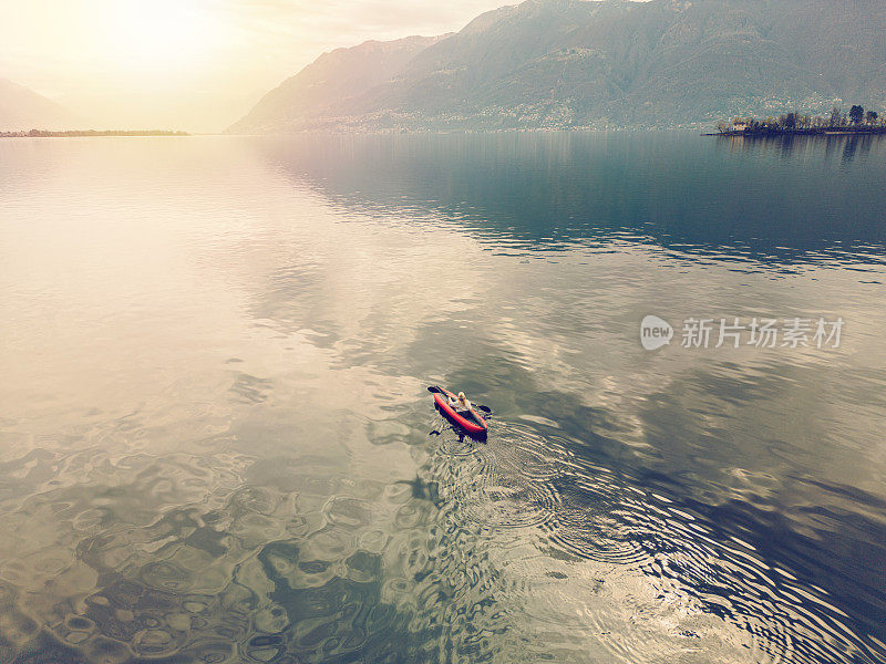 女人在平静的湖面上划独木舟，无人机鸟瞰图