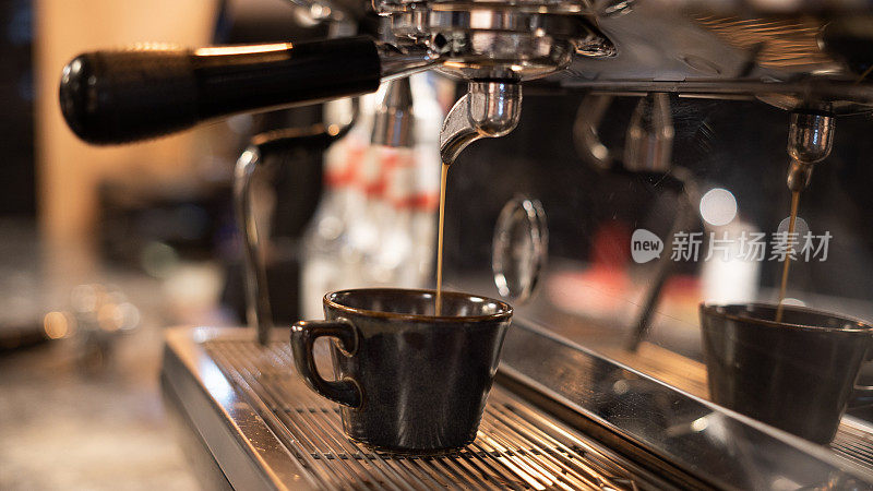 咖啡杯立在浓缩咖啡机里