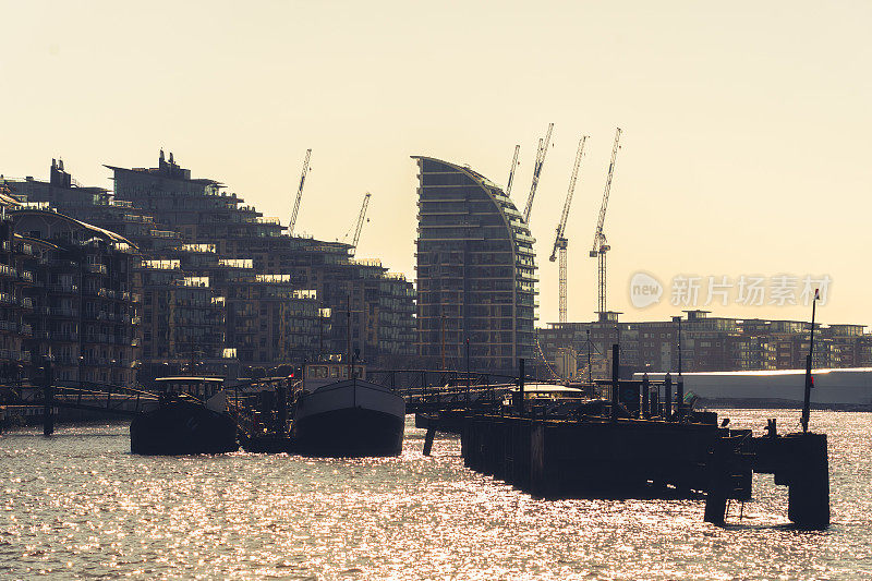 泰晤士河边的旧船和伦敦切尔西的现代建筑