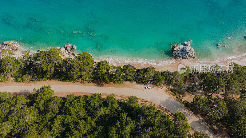 鸟瞰图，汽车和帐篷在土耳其的森林和绿松石海的风景公路