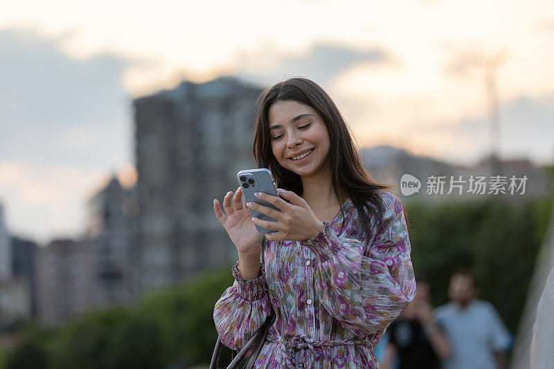 衣着讲究的年轻女子正在用便携式设备查看邮件。