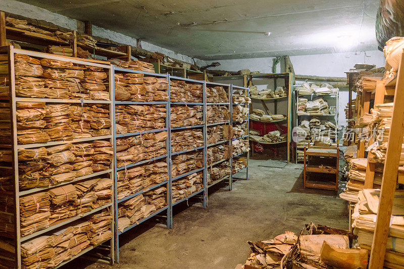 一个废弃的苏联行政大楼的房间，旧的档案文件堆放在架子上