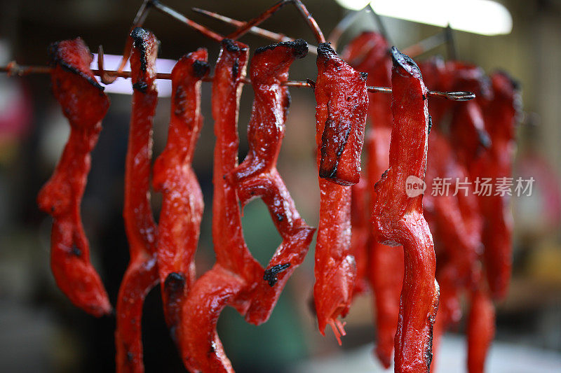 刚烤好的中国叉烧猪肉挂在市场摊位上出售