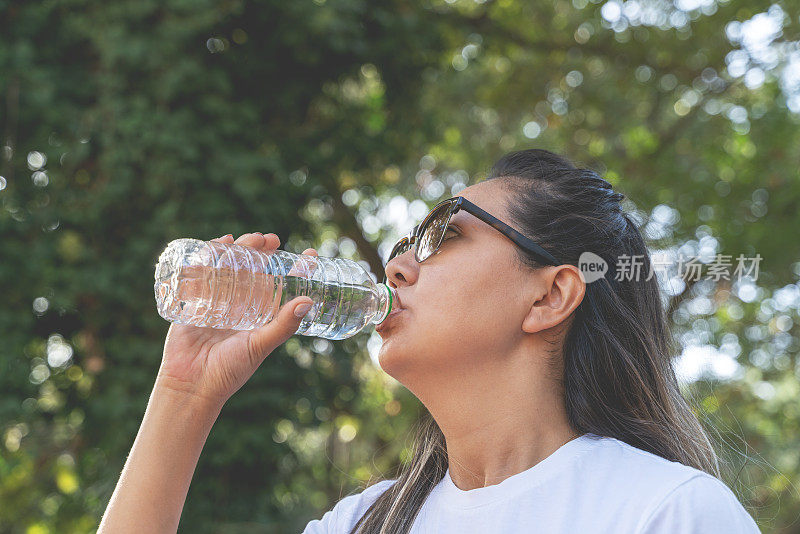 运动的年轻女子喝水的照片