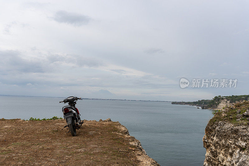 摩托车停在印尼巴厘岛巴兰干海滩的悬崖边