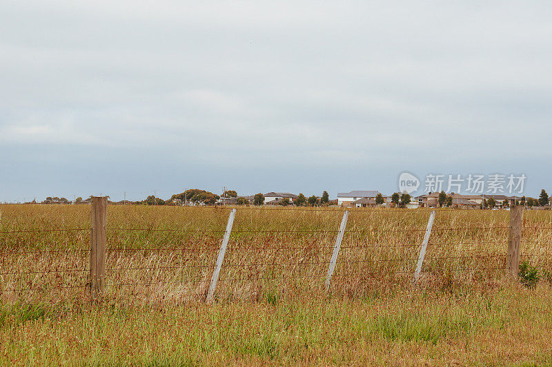 夏季田野的干草和墨尔本西部的远郊住宅区