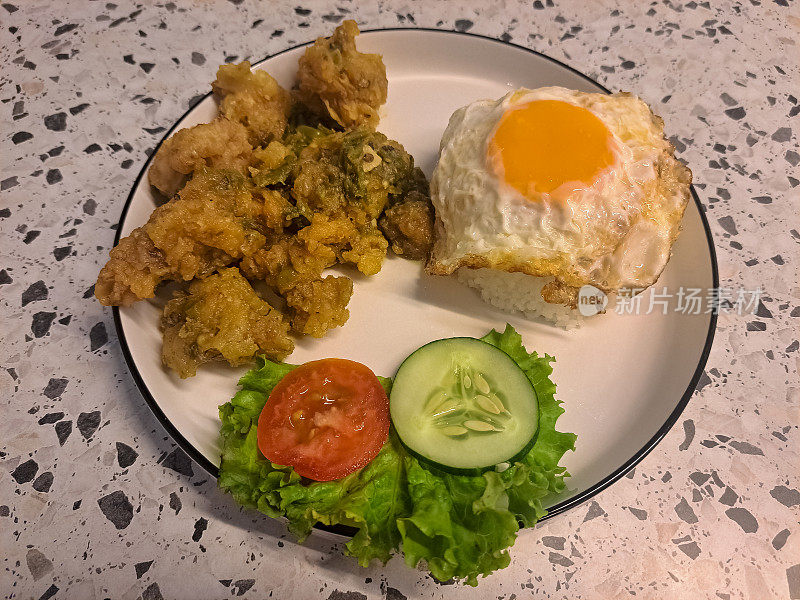 美味的青椒炸鸡配米饭，鸡肉，煎蛋，生菜，番茄片和黄瓜片。食品菜单。