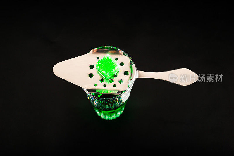 一种叫苦艾酒的绿色伏特加，装在小玻璃杯里，用特制的勺子和白糖块盛着