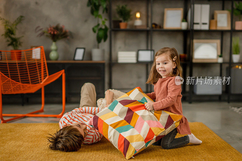 孩子们在家里的地板上玩枕头，打枕头仗
