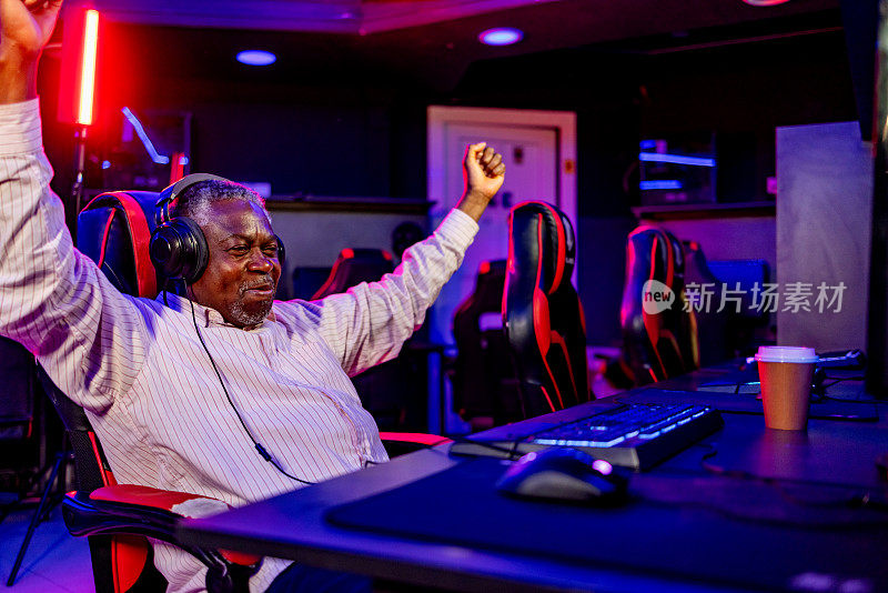 一位老人在电子游戏中庆祝胜利，握紧拳头，面带微笑