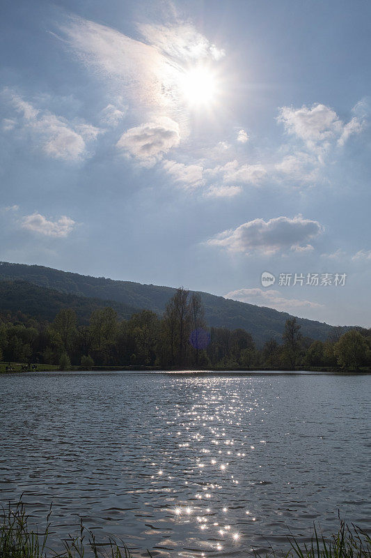阳光明媚的一天，湖上的阳光反射在波光粼粼的水面上