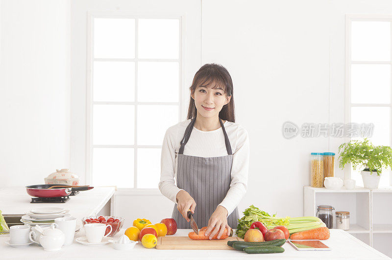 年轻女人在厨房切红萝卜