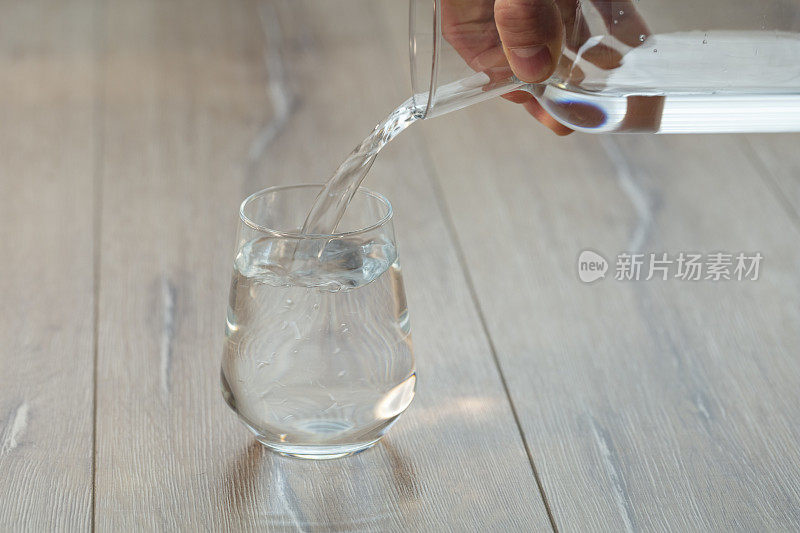 将苏打水或水倒入加冰的普通玻璃杯中