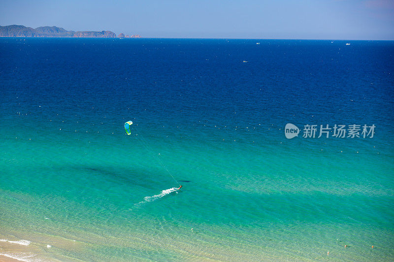 风筝冲浪在热带碧水海滩上从空中鸟瞰拍摄的照片