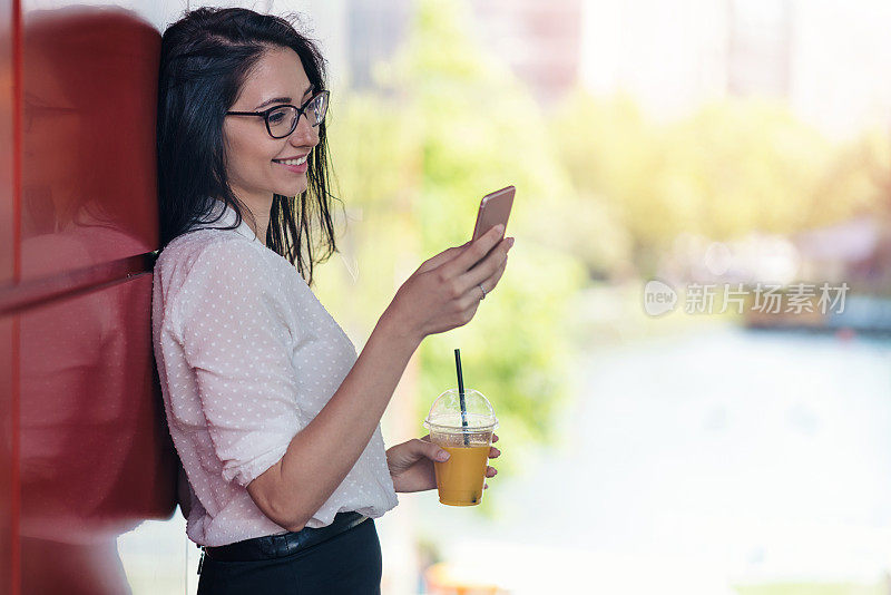 微笑的商务女士在午休时间发短信